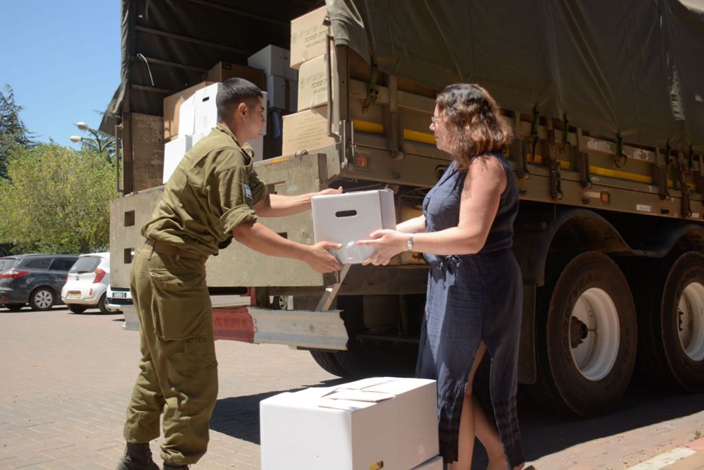 Los residentes de los Altos del Golán de Israel entregan paquetes de asistencia de las FDI para los sirios desplazados que huyen de la guerra civil en Siria, julio de 2018. (FDI)