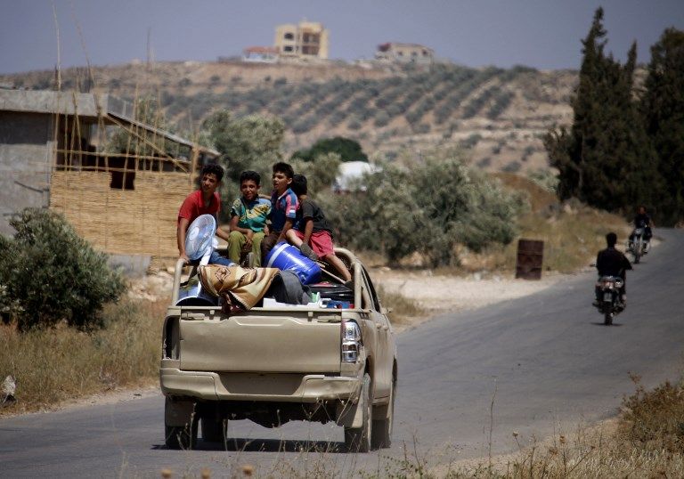 Los sirios viajan en un vehículo con sus pertenencias personales cuando regresan a sus hogares en las ciudades y pueblos situados en las afueras al este de Daraa el 7 de julio de 2018. (AFP Photo / Mohamad Abazeed)