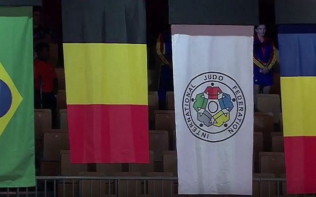 Las banderas nacionales de los ganadores de medallas en el Grand Slam de Judo 2017 en Abu Dhabi, con la bandera israelí reemplazada por la bandera de la Federación Internacional de Judo (segunda desde la derecha) debido a la prohibición de la Federación de Judo de los Emiratos Árabes sobre símbolos israelíes en el evento. El israelí Gili Cohen se llevó el bronce en la competencia, que tuvo lugar el 26 de octubre de 2017. Las otras banderas, de izquierda a derecha, son de Brasil, Bélgica y Rumania. (Captura de pantalla de YouTube)