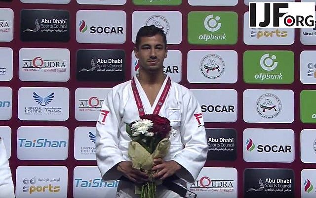El judoka israelí medallista de oro Tal Flicker está en el podio en el Grand Slam de Judo en Abu Dhabi, donde las autoridades locales de judo prohibieron la exhibición de todos los símbolos israelíes, el 26 de octubre de 2017. (captura de pantalla de YouTube)