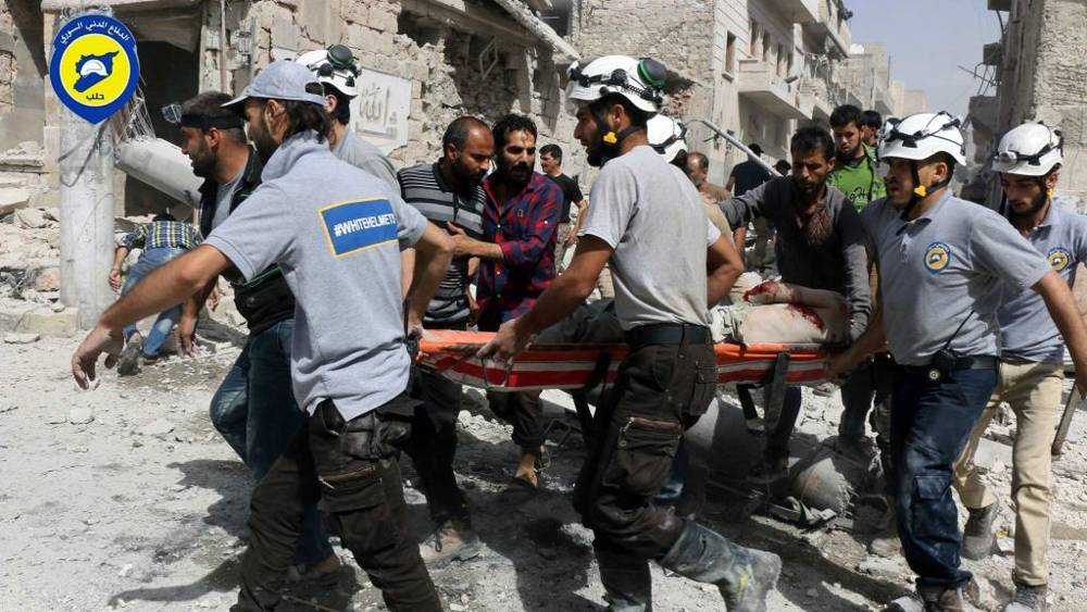 Los trabajadores de rescate trabajan en el lugar de los ataques aéreos en el vecindario de al-Sakhour de la parte del este de Alepo, Siria, controlada por los rebeldes, Siria, 21 de septiembre de 2016. (Cascos blancos de la Defensa Civil siria a través de AP).