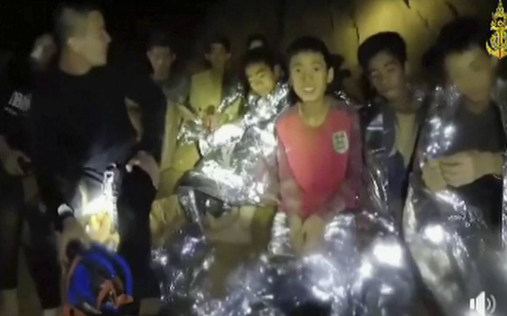 En esta imagen del 3 de julio de 2018, los niños tailandeses atrapados están con los Navy SEAL dentro de una cueva en el norte de Tailandia (Thai Navy Seal vía AP)