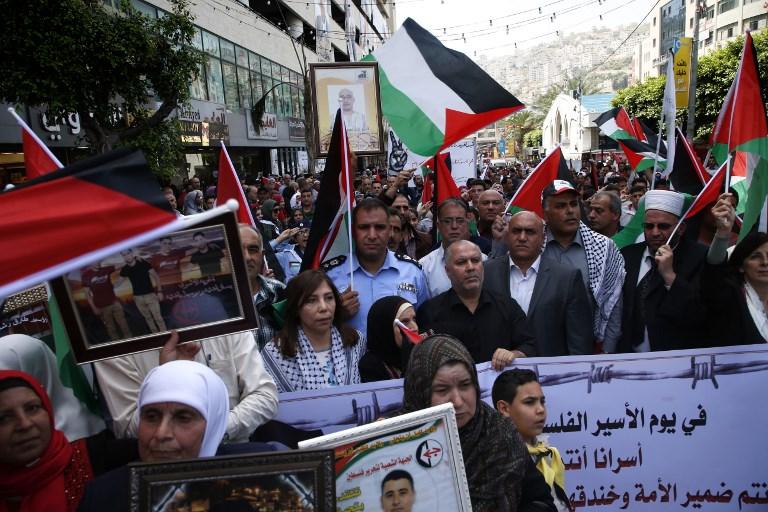 Árabes palestinos sostienen retratos de familiares terroristas encarcelados en prisiones israelíes mientras protestan para exigir su liberación durante una manifestación para conmemorar el Día del Preso en la ciudad de Nablus, el 17 de abril de 2018. (AFP PHOTO / JAAFAR ASHTIYEH)
