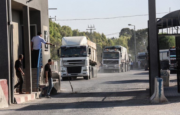 Las fuerzas de seguridad palestinas leales a la Autoridad Palestina permanecen en la entrada del cruce Kerem Shalom, el principal punto de paso para los bienes que ingresan a Gaza, en la ciudad de Rafah, al sur de la Franja de Gaza, el 9 de julio de 2018. (AFP PHOTO / SAID KHATIB)
