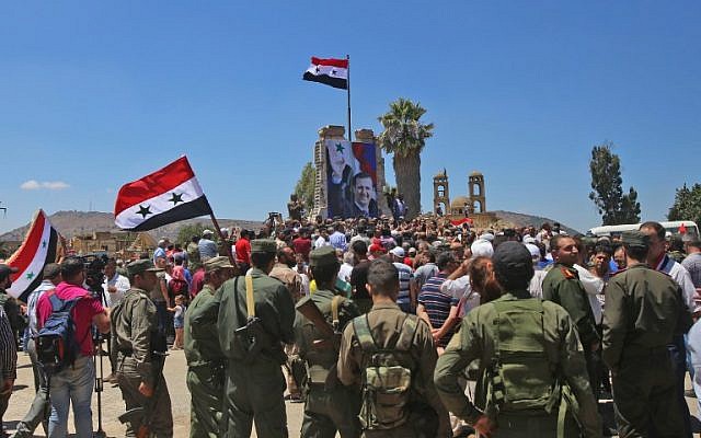 Las tropas sirias levantan la bandera siria en la ciudad fronteriza de Quneitra en los Altos del Golán sirio el 27 de julio de 2018. (AFP Photo / Youssef Karwashan)