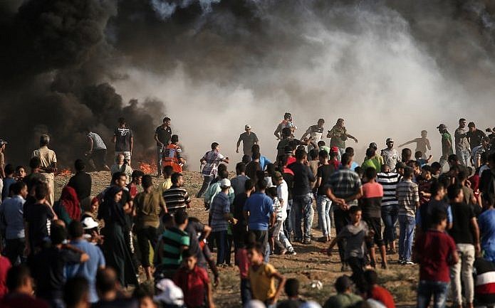 El humo del incendio de un neumático se eleva cuando los palestinos protestan cerca de la frontera con Israel, al este de la ciudad de Gaza, el 17 de agosto de 2018 (AFP PHOTO / MAHMUD HAMS)
