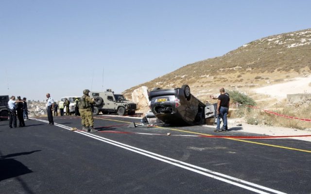 La policía israelí busca evidencia en la escena donde mataron a Miki Mark y tres miembros de su familia resultaron heridos cuando un terrorista palestino abrió fuego contra su automóvil, el 1 de julio de 2016, al sur de Hebrón. (AFP / Hazem Bader)