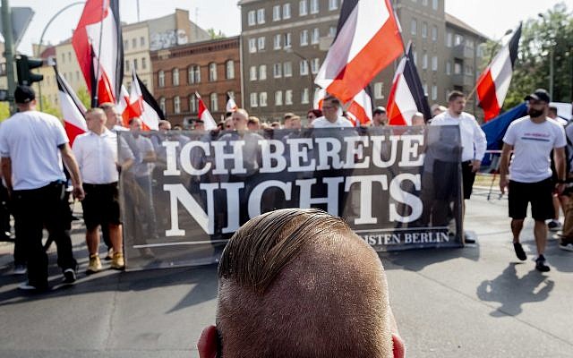La gente lleva una pancarta que dice "No me arrepiento" durante una manifestación en conmemoración del 31º aniversario de la muerte. El teniente de Hitler Rudolf Hess en Berlín el sábado 18 de agosto de 2018. Hess murió en 1987 en una prisión en Berlín. (Christoph Soeder / dpa vía AP)