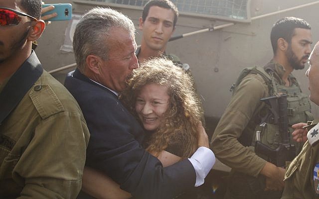 Ahed Tamimi, centro derecha, es abrazado por su padre Bassem cuando es liberada por el ejército israelí después de cumplir una condena de ocho meses, vista aquí cuando llegó a la entrada de su pueblo de Nebi Saleh en Cisjordania el 29 de julio de 2018. (Nasser Shiyoukhi / AP)