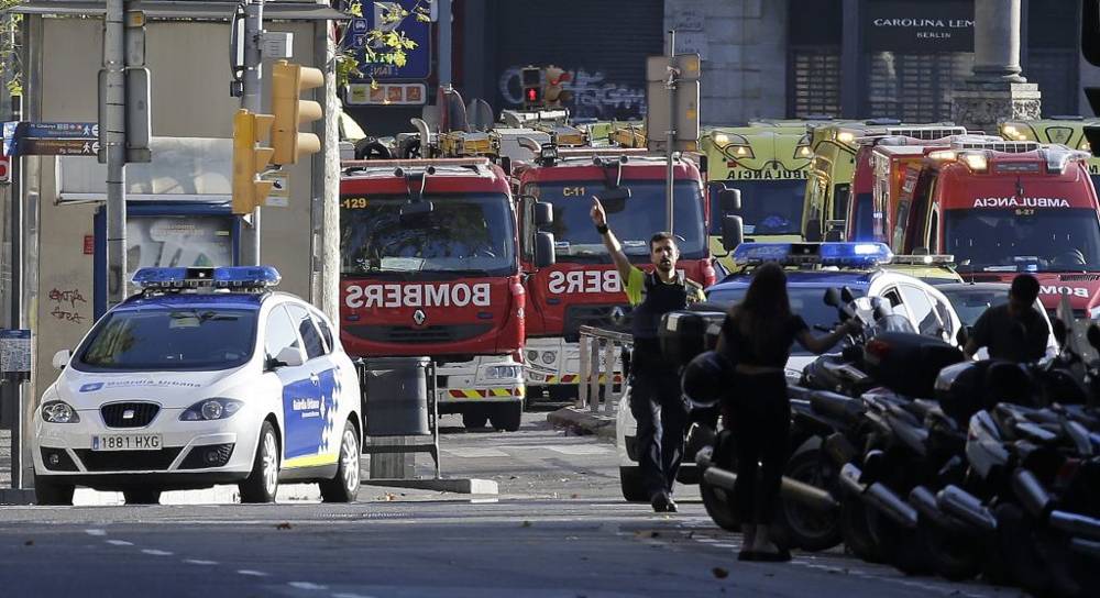 Un oficial de policía hace un gesto mientras bloquea una calle después de un ataque terrorista en el que una furgoneta blanca saltó la acera en el histórico barrio de Las Ramblas, en Barcelona, ​​España, el 17 de agosto de 2017. Manu Fernández / AP)