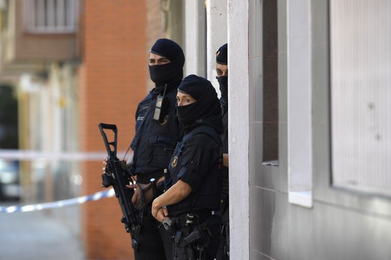 La policía regional catalana (Mossos d'Esquadra) hace guardia fuera del edificio de apartamentos de un hombre que intentó atacar una estación de policía en Cornella, cerca de la ciudad de Barcelona el noreste de España, el 20 de agosto de 2018. (LLUIS GENE / AFP)