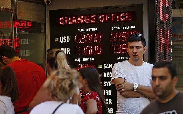 La gente se alinea en una tienda de cambio de moneda en Estambul, el martes, 14 de agosto de 2018. (AP Photo / Lefteris Pitarakis)