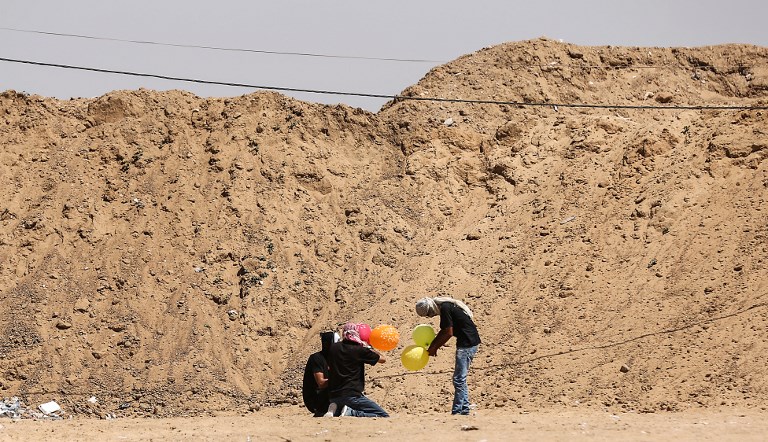Ilustrativo: los habitantes de Gaza cargan globos con material inflamable para volar hacia Israel, en la frontera entre Israel y Gaza en al-Bureij, en el centro de la Franja de Gaza el 14 de junio de 2018. (AFP / Hams Mahmud)