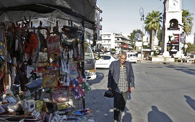 Un hombre sirio pasa frente a un puesto en la ciudad septentrional siria controlada por los rebeldes de la Plaza del Reloj central de Idlib el 6 de septiembre de 2018. (AFP / Zein Al RIFAI)