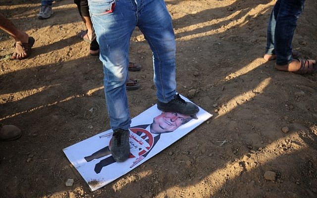 Un manifestante palestino está pisando un letrero que representa al presidente estadounidense Donald Trump con una leyenda debajo de la lectura en árabe: "Volvemos a pesar de ti, Trump" durante una manifestación en la frontera entre Israel y Gaza, al este de la ciudad de Gaza en el centro Franja de Gaza el 7 de septiembre de 2018 (AFP PHOTO / SAID KHATIB)