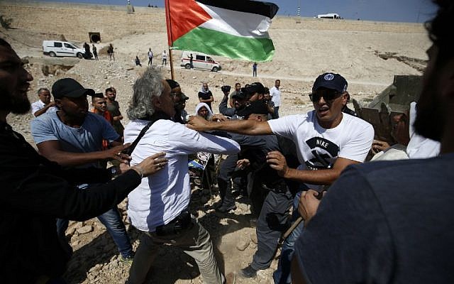 Las fuerzas de seguridad israelíes se pelean con el manifestante franco-estadounidense Frank Romano el 14 de septiembre de 2018, durante una protesta contra la esperada demolición de la aldea beduina de Khan al-Ahmar en Cisjordania. (AFP PHOTO / ABBAS MOMANI)