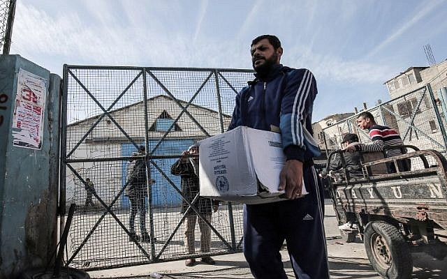 Los refugiados palestinos recogen paquetes de ayuda en un centro de distribución de alimentos de las Naciones Unidas en Rafah, en el sur de la Franja de Gaza, el 21 de enero de 2018. (AFP / Said Khatib)