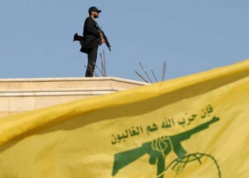 Un miembro de Hezbolá porta su arma en la parte superior de un edificio el 25 de mayo de 2016 .. (crédito de la foto: HASSAN ABDALLAH / REUTERS)