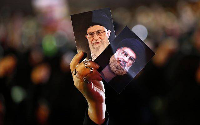 Un partidario de Hezbolá sostiene retratos del líder de Hezbolá, jeque Hassan Nasrallah, derecha, y el líder supremo iraní ayatolá Ali Khamenei, izquierda, durante las actividades para conmemorar el noveno Ashura, un ritual de 10 días para conmemorar la muerte del imán Hussein en un suburbio del sur de Beirut, Líbano, el 19 de septiembre de 2018. (AP Photo / Hussein Malla)