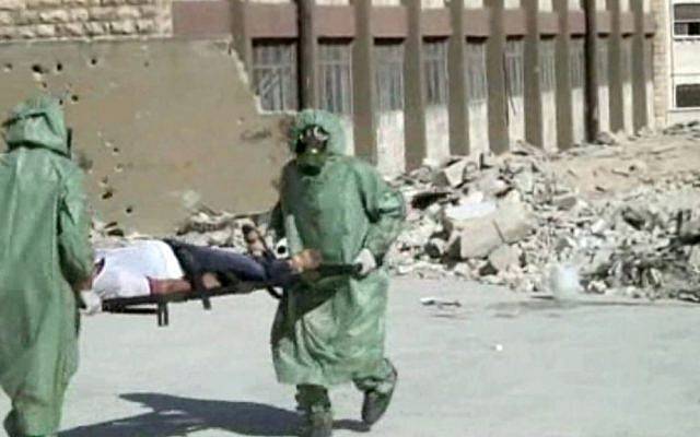 Foto ilustrativa: Esta imagen, de un video publicado el 18 de septiembre de 2013, muestra a sirios con trajes de protección y máscaras antigás conduciendo un simulacro sobre cómo tratar a las víctimas de un ataque con armas químicas, en Aleppo, Siria (AP)