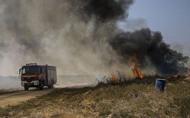 Bomberos israelíes llegan a un campo incendiado por un globo incendiario lanzado por los palestinos desde la Franja de Gaza, el lunes 3 de septiembre de 2018 cerca de la frontera con Gaza. (AP Photo / Tsafrir Abayov)