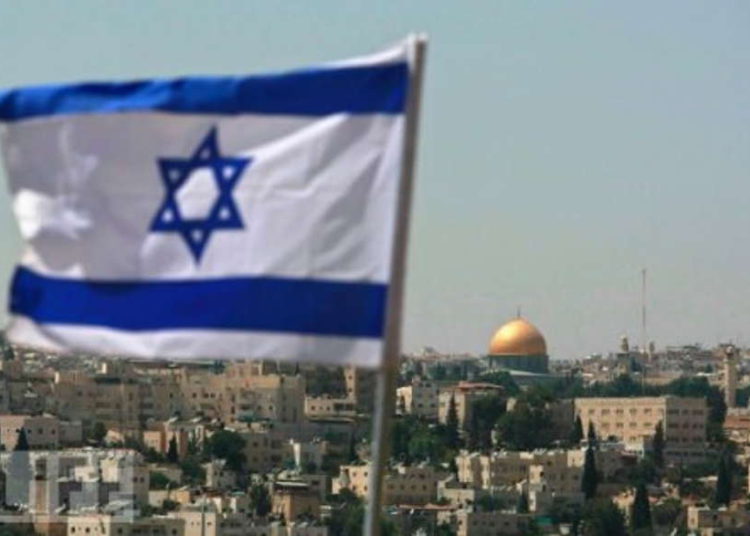 La bandera de Israel volando en Jerusalén con el Monte del Templo en la distancia