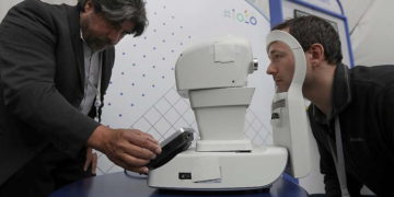 Jorge Cuadros, izquierda, ofrece una demostración de una cámara de retina robótica a un periodista en la conferencia Google I / O en Mountain View, California, el 8 de mayo de 2018 (AP Photo / Jeff Chiu)