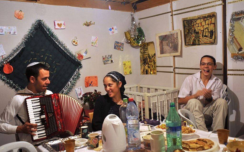 Ilustrativo: familia israelí comiendo en la sucá durante la segunda noche de Sucot en el barrio judío de la Ciudad Vieja de Jerusalén. (crédito de la foto: Serge Attal / Flash 90)