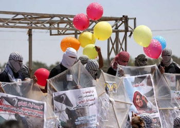 Los palestinos cargan cometas y globos con material inflamable para volar hacia Israel, en la frontera Israel-Gaza en al-Bureij, en el centro de la Franja de Gaza, el 14 de junio de 2018. (AFP Photo / Mahmud Hams