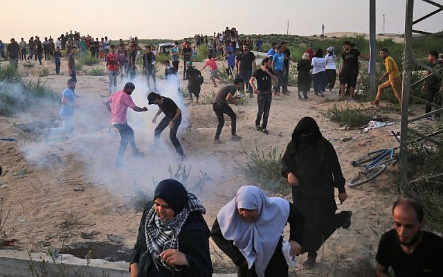 Los manifestantes palestinos se manifiestan con humo de gas lacrimógeno en el cruce fronterizo de Erez con Israel en el norte de la Franja de Gaza el 3 de octubre de 2018. (AFP PHOTO / DICE KHATIB)