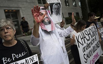 Un manifestante vestido como el príncipe heredero de Arabia Saudita Mohammed bin Salman (C) con sangre en sus manos protestas frente a la Embajada de Arabia Saudita en Washington, DC, el 8 de octubre de 2018, exigiendo justicia por el desaparecido periodista Jamal Khashoggi. (Jim Watson / AFP)