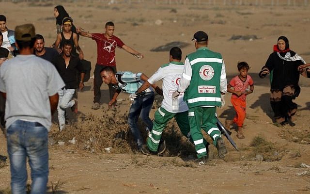 Los paramédicos ayudan a un palestino en la frontera entre Israel y Gaza, al este de la ciudad de Gaza, el 12 de octubre de 2018. (Dijo KHATIB / AFP)