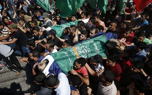 Los palestinos llevan los cadáveres de Ahmad al-Tawil (R) y Ahmed Abu Naim (L), que fueron asesinados el día anterior durante un atque terrorista a lo largo de la valla de la frontera entre Israel y Gaza, durante su funeral en el campamento de Nuseirat, en el centro de la Franja de Gaza. 13 de octubre de 2018. (Dijo KHATIB / AFP)