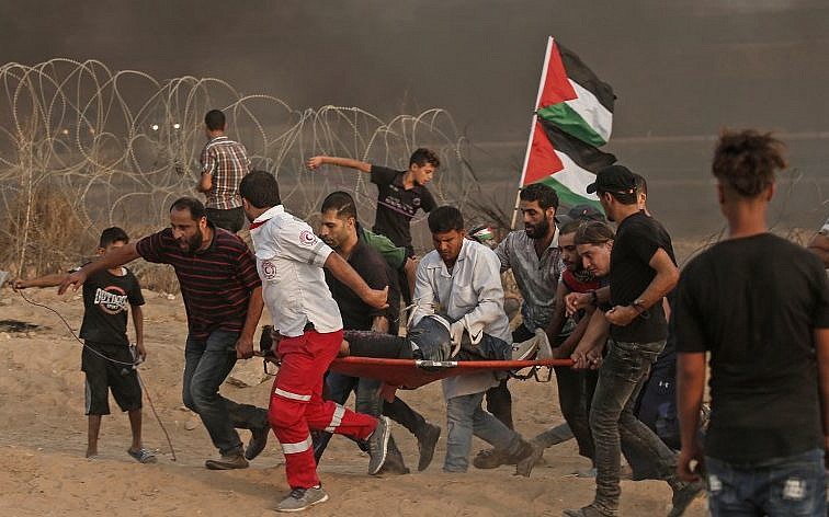 Los paramédicos palestinos llevan a un manifestante herido durante una manifestación cerca de la frontera con Israel, al este de la ciudad de Gaza, el 19 de octubre de 2018. (Mahmud Hams / AFP)