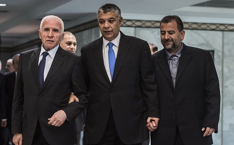 Khaled Fawzi, jefe de los servicios de inteligencia egipcios, llega con Azzam al-Ahmad de Fatah, a la izquierda, y Saleh al-Arouri de Hamás, a la derecha, antes de firmar un acuerdo de reconciliación en El Cairo el 12 de octubre de 2017, como los dos rivales palestinos. Los movimientos terminaron su división de una década después de las negociaciones supervisadas por Egipto. (AFP / Khaled Desouki)