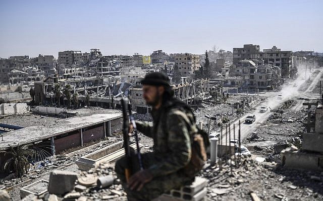 Ilustrativo: un luchador de las Fuerzas Democráticas de Siria (SDF) se sienta en guardia en un tejado en Raqa el 20 de octubre de 2017, después de retomar la ciudad de combatientes del grupo Estado Islámico (IS). (AFP PHOTO / BULENT KILIC)