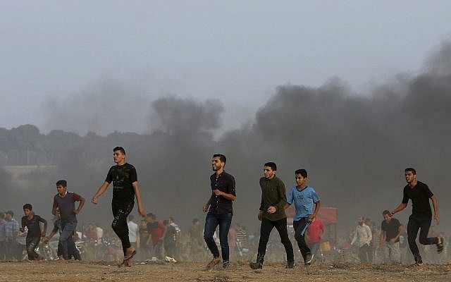 Palestinos cerca de la frontera de la Franja de Gaza con Israel al este de Khan Younis, sur de la Franja de Gaza, viernes 19 de octubre de 2018. (Foto AP / Adel Hana)
