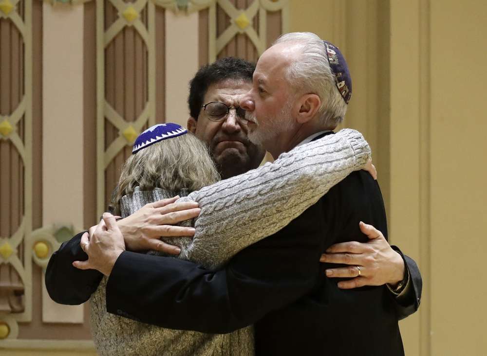 El rabino Jeffrey Myers, a la derecha, de Árbol de la Vida abraza al rabino Cheryl Klein, a la izquierda, de la Congregación Dor Hadash y el rabino Jonathan Perlman durante una reunión comunitaria celebrada tras un tiroteo mortal en la Sinagoga Árbol de la Vida en Pittsburgh, 28 de octubre de 2018. (Foto AP / Matt Rourke)