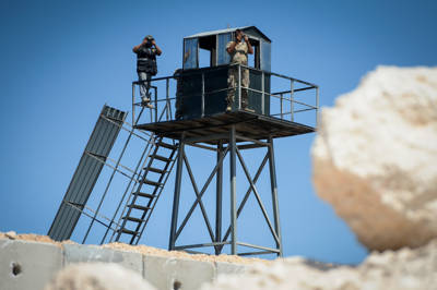 Soldados libaneses y un miembro de Hezbolá(izquierda) vistos en una torre de vigilancia cerca del nuevo muro de hormigón en la frontera entre Israel y el Líbano, cerca de Rosh Hanikra en el norte de Israel el 5 de septiembre de 2018. Foto de Basel Awidat / Flash90.