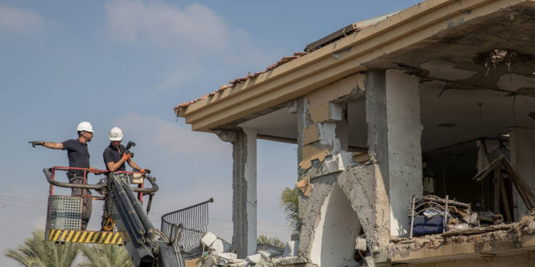 Las fuerzas de seguridad israelíes inspeccionan un edificio que fue alcanzado por un cohete disparado desde la Franja de Gaza en la ciudad de Beersheba, sur de Israel, el 17 de octubre de 2018. (Yonatan Sindel / Flash90)