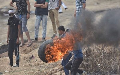 Los terroristas palestinos lanzan neumáticos quemados a la valla de seguridad de Gaza durante la  'Marcha de retorno' el 4 de mayo de 2018. (Fuerzas de defensa de Israel)