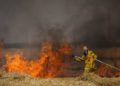 Bomberos israelíes apagan un incendio en un campo de trigo causado por cometas voladas por terroristas palestinos, cerca de la frontera con la Franja de Gaza, 30 de mayo de 2018. (Yonatan Sindel / Flash90)