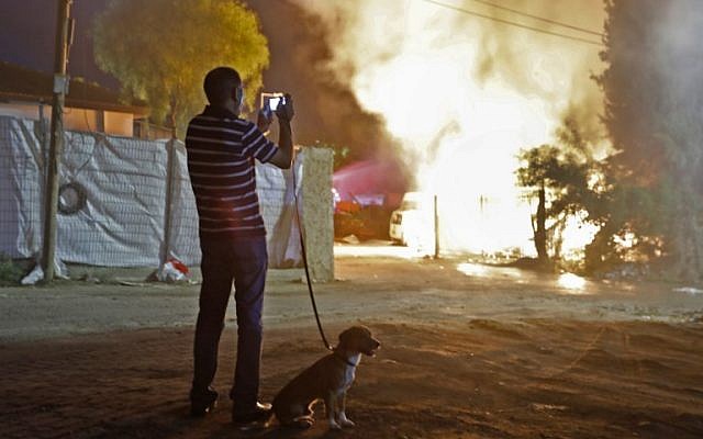 Un hombre mira un edificio que fue incendiado luego de ser alcanzado por un cohete lanzado desde la Franja de Gaza, en la ciudad de Sderot, sur de Israel, el 12 de noviembre de 2018. (Menahem KAHANA / AFP)