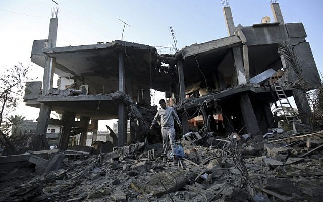 Palestinos caminan entre escombros de un edificio que fue destruido en un ataque aéreo israelí en Khan Yunis en el sur de la Franja de Gaza el 13 de noviembre de 2018. (Dijo KHATIB / AFP)