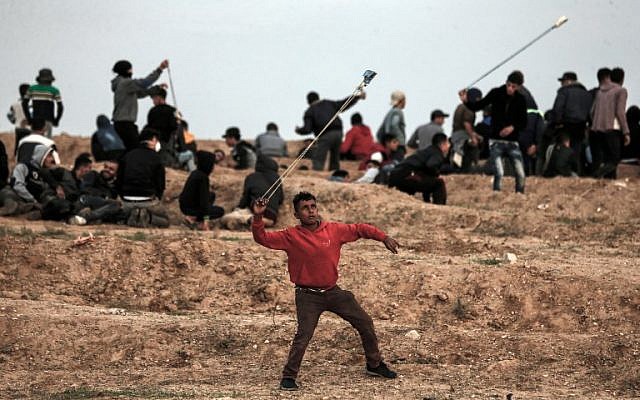 Un manifestante palestino usa una honda para arrojar piedras hacia las fuerzas israelíes durante una protesta el 16 de noviembre de 2018, en las afueras del este de la ciudad de Gaza, cerca de la frontera con Israel. (Foto por MAHMUD HAMS / AFP)