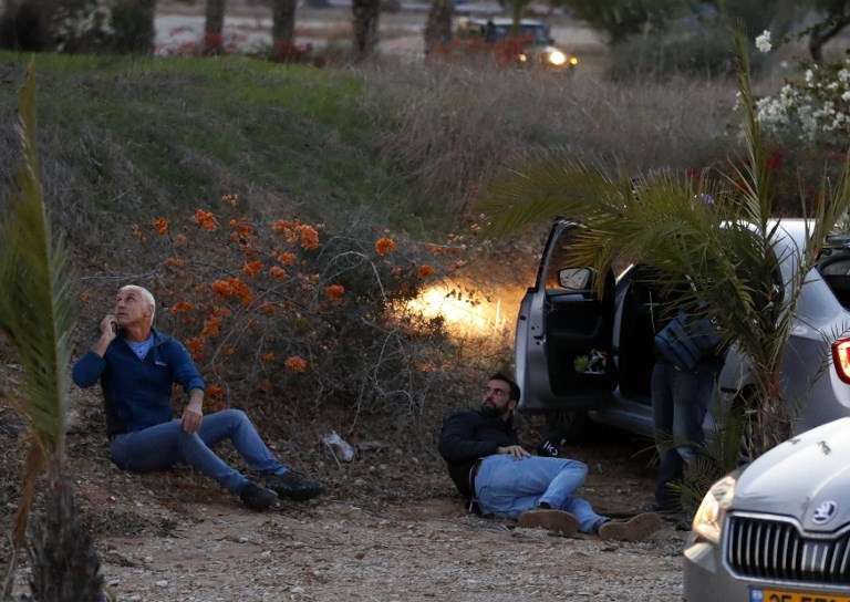 Los israelíes se protegen mientras se disparan cohetes desde la Franja de Gaza, en la ciudad de Sderot, sur de Israel, el 12 de noviembre de 2018 (Jack GUEZ / AFP)