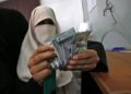 Una mujer palestina cuenta su dinero luego de recibir su salario en Rafah, en el sur de la Franja de Gaza, el 9 de noviembre de 2018. (Said Khatib / AFP)