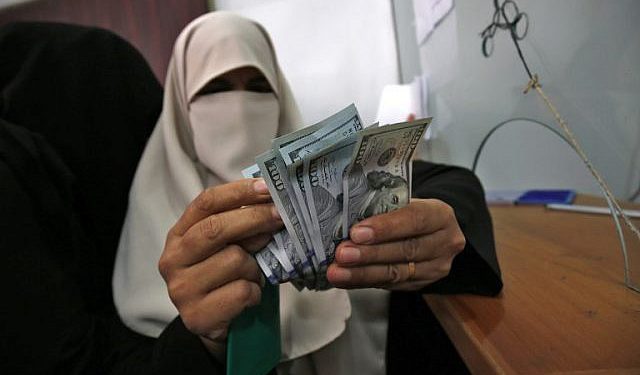 Una mujer palestina cuenta su dinero luego de recibir su salario en Rafah, en el sur de la Franja de Gaza, el 9 de noviembre de 2018. (Said Khatib / AFP)