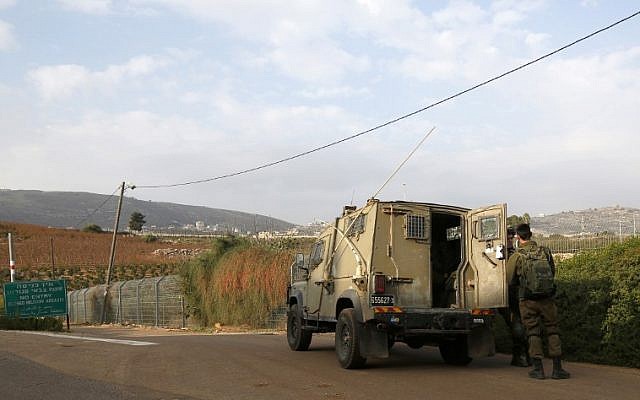 Esta fotografía tomada el 4 de diciembre de 2018 cerca de la ciudad de Metula, en el norte de Israel, muestra a soldados israelíes de pie frente a un vehículo militar cerca de la frontera con el Líbano. (JALAA MAREY / AFP)