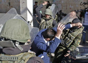 Las fuerzas de seguridad palestinas golpearon a un partidario de Hamas cuando intentaban dispersar una manifestación que conmemora el 31 aniversario de la fundación del grupo terrorista en Hebrón el 14 de diciembre de 2018. (Hazem Bader / AFP)